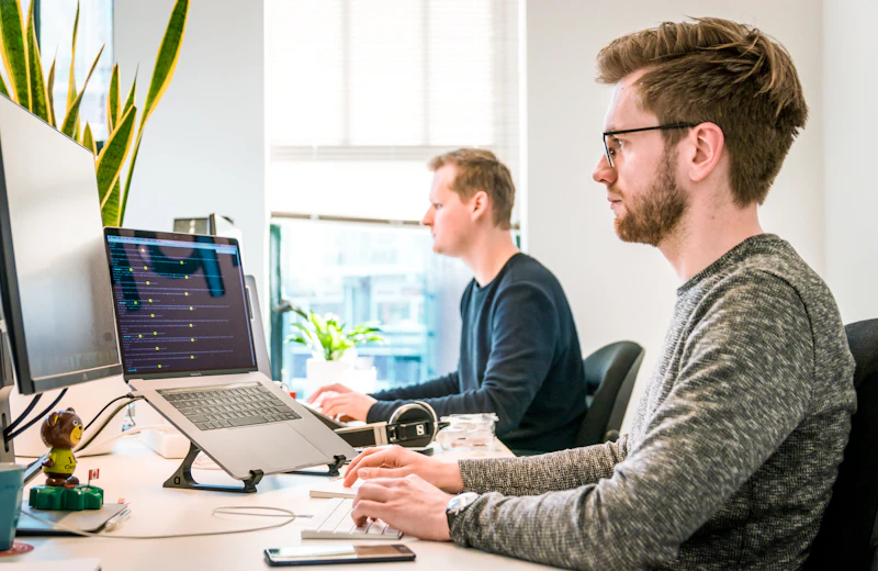 Two developers reviewing website performance on screen